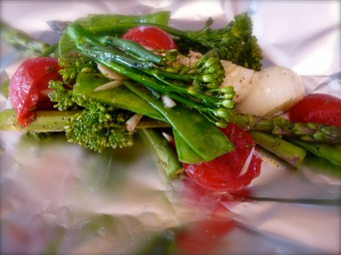 Vegetables, seasoned and tossed in olive oil, sitting on their tinfoil home, ready to be wrapped.