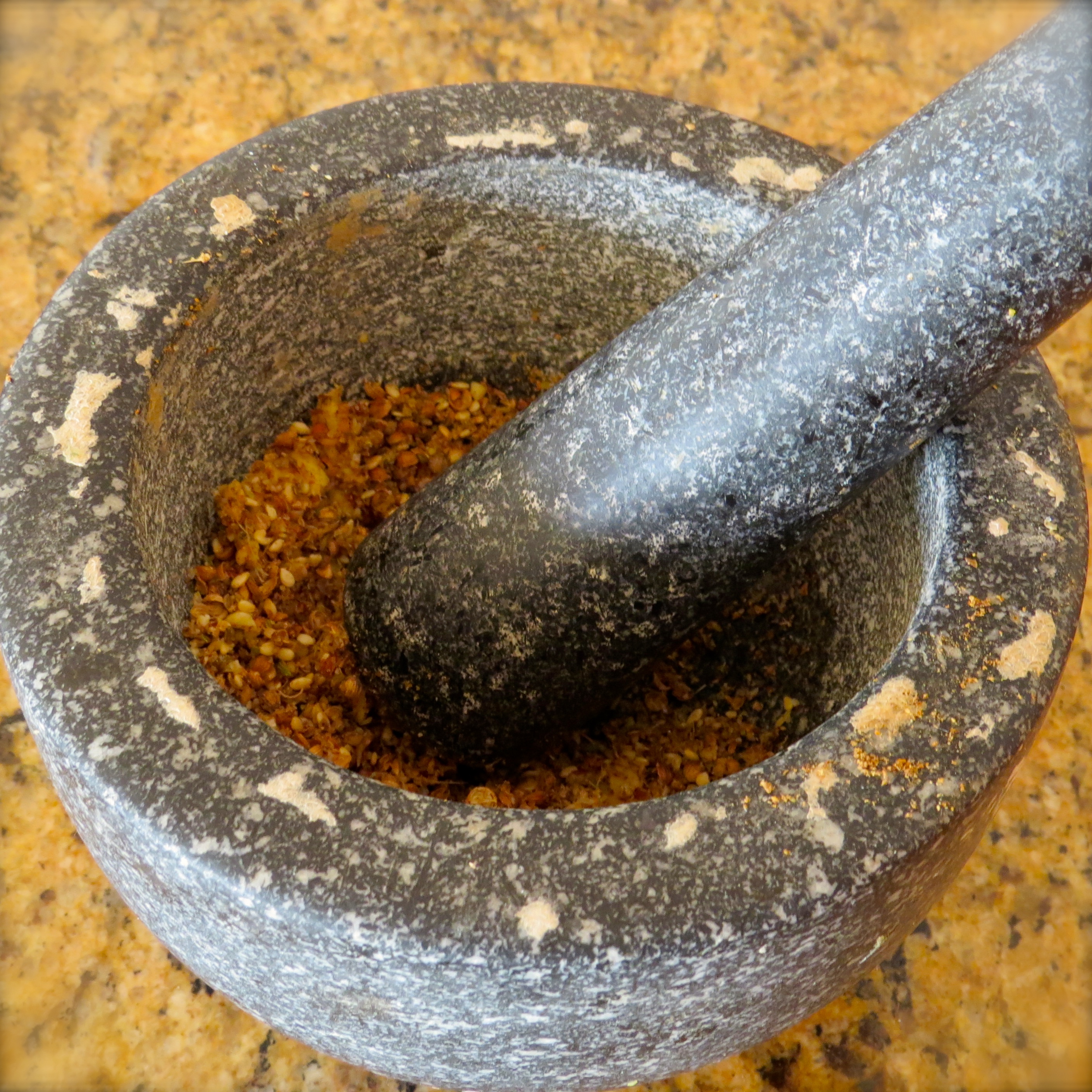 The spices and ginger slices are thrown into the mortar and coarsely crushed with my trusty pestle.