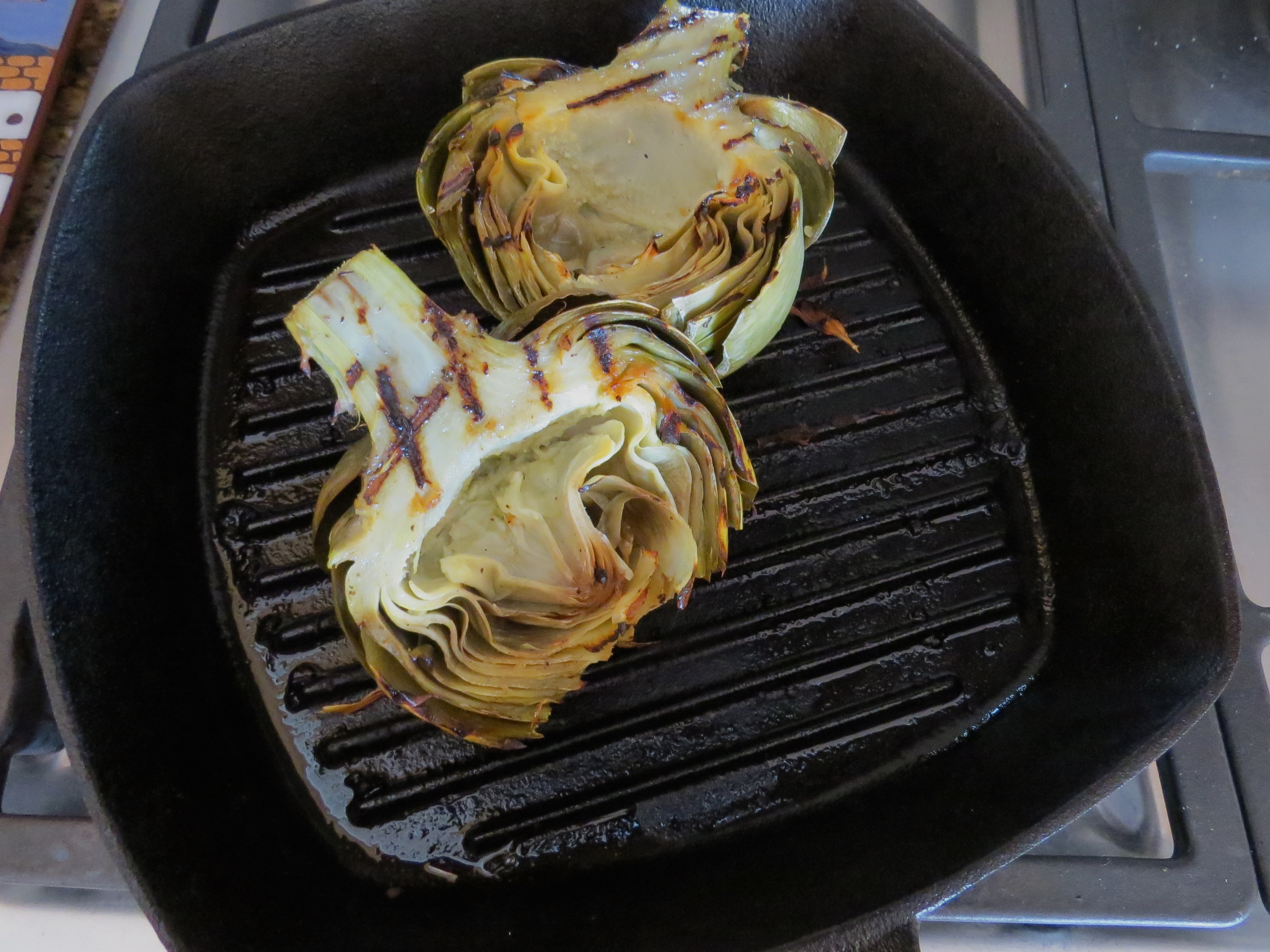 I mixed together 2 sliced garlic cloves, 1 Tbs, lemon juice, 1/2 tsp of salt and pepper and 2 TBS olive oil. After brushing the entire artichoke halves with the mix, I grilled them for 6 minutes, 3 minutes for each side. No condiments needed for serving...so good.