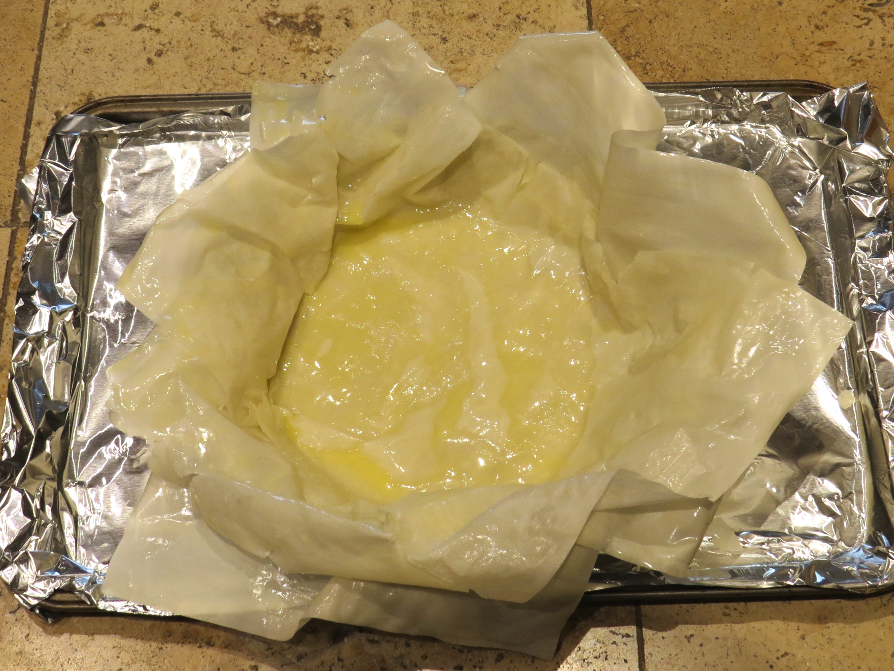 The first four buttered filo sheets make the shell of the pie.