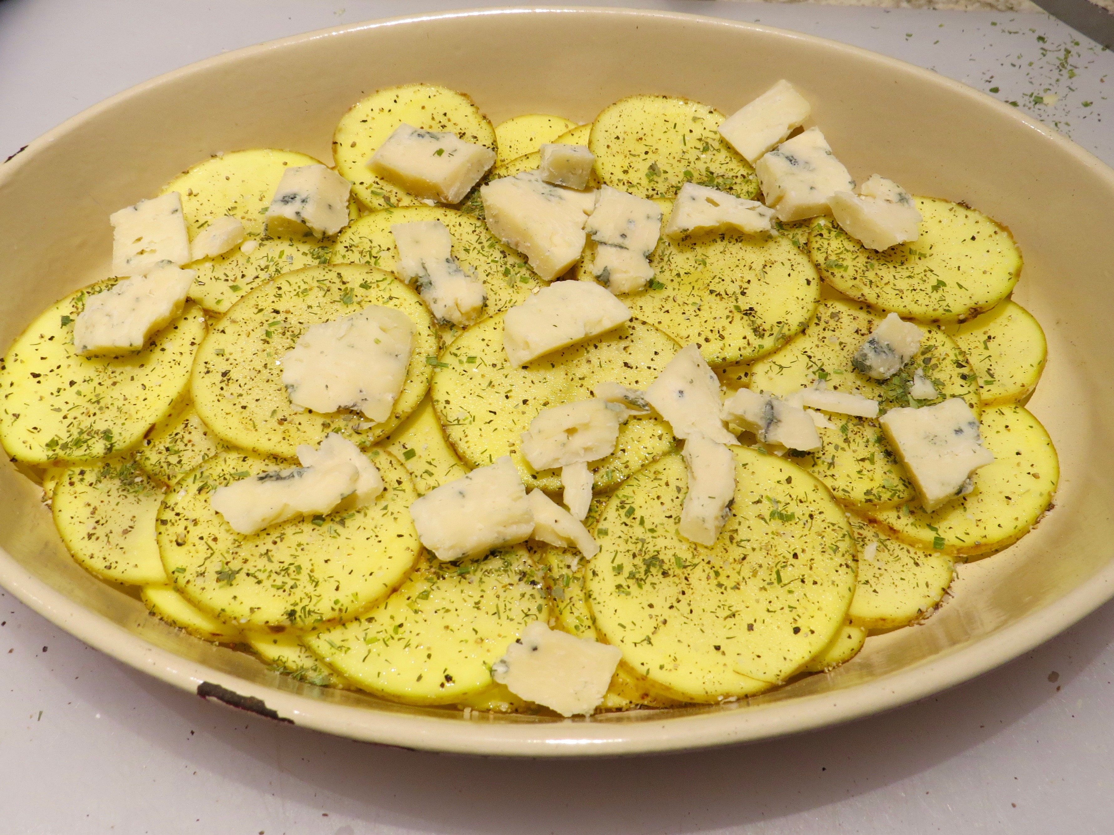 Layer #1 - sliced potatoes, bleu cheese and seasoning.